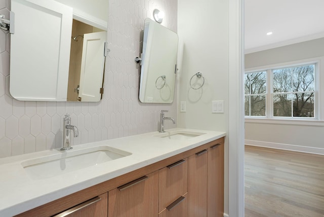 full bathroom featuring ornamental molding, a sink, and decorative backsplash