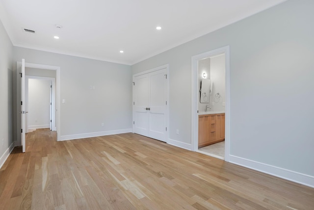 unfurnished bedroom with light wood-style floors, baseboards, visible vents, and a sink