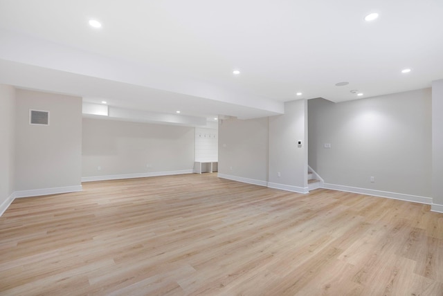 finished below grade area featuring recessed lighting, baseboards, visible vents, and light wood finished floors