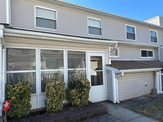 townhome / multi-family property featuring roof with shingles