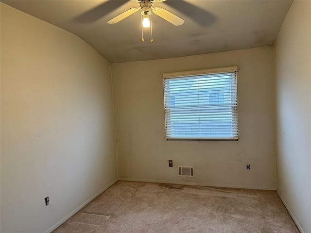 empty room with light carpet, visible vents, baseboards, vaulted ceiling, and a ceiling fan