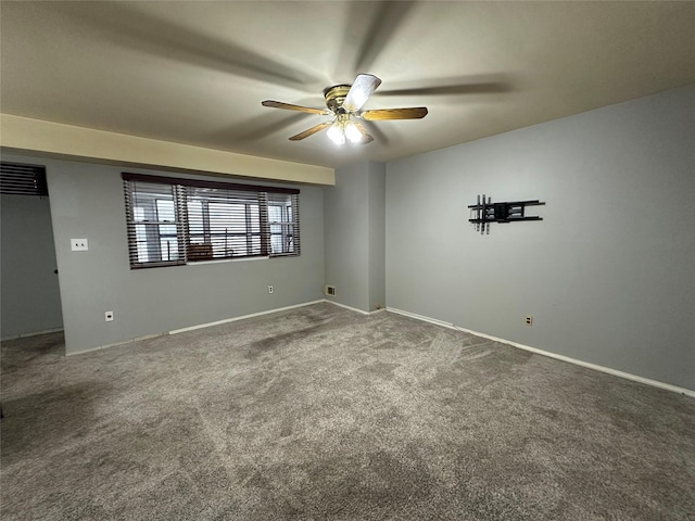 carpeted spare room featuring ceiling fan and baseboards