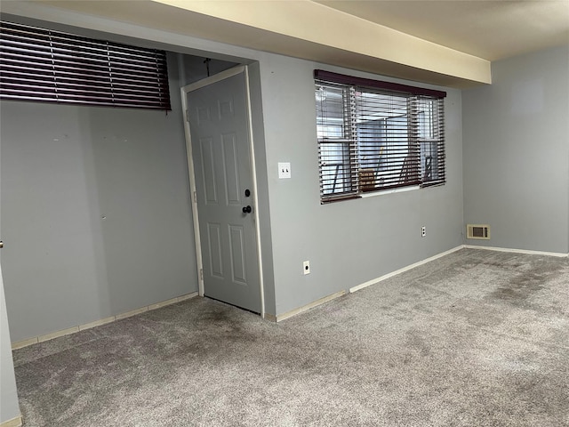 carpeted spare room featuring visible vents and baseboards