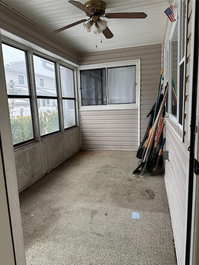 unfurnished sunroom featuring a ceiling fan