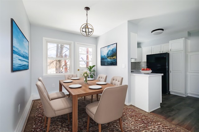 dining room with an inviting chandelier and dark wood-type flooring