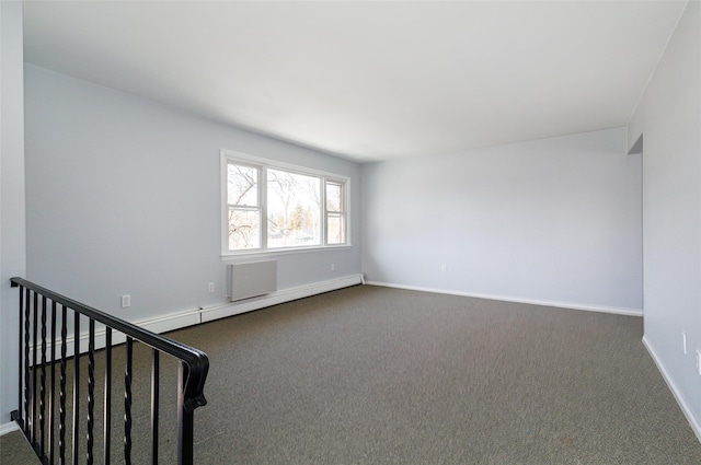 carpeted spare room with a baseboard heating unit