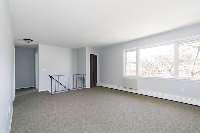 spare room featuring carpet and a baseboard radiator