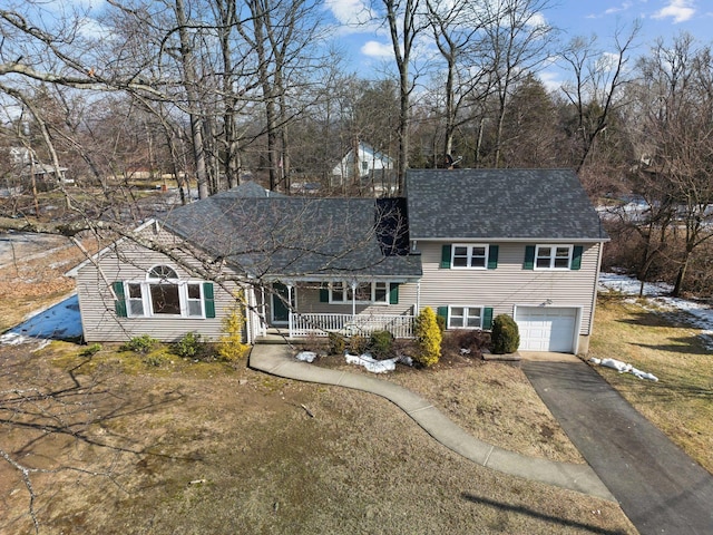 view of front of house featuring driveway, covered porch, and a garage