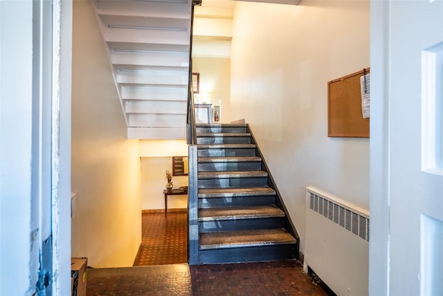 staircase with baseboards and radiator