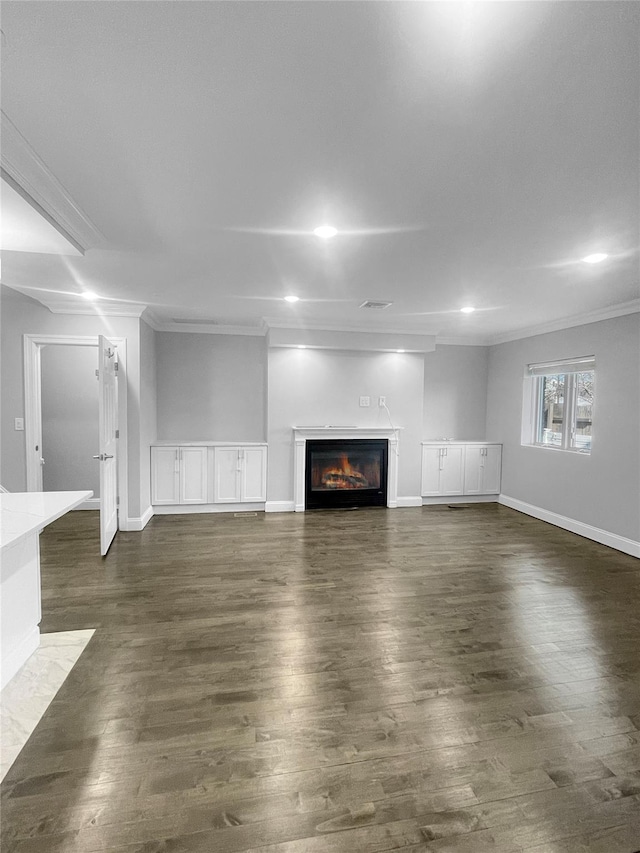 unfurnished living room with dark hardwood / wood-style floors and ornamental molding