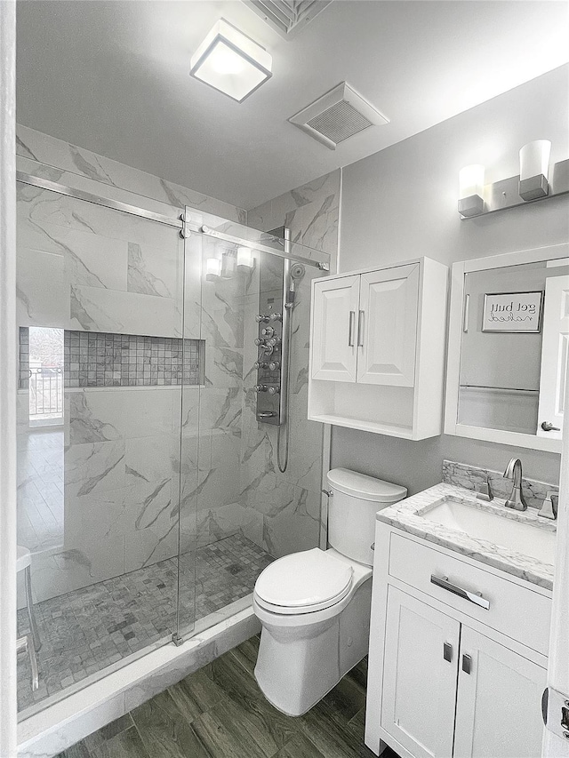 bathroom with toilet, vanity, walk in shower, and hardwood / wood-style floors