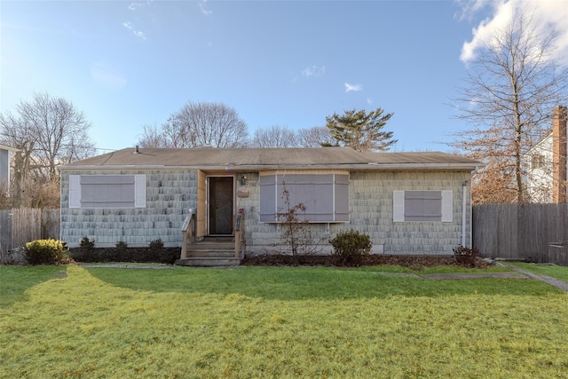 ranch-style house with fence and a front lawn