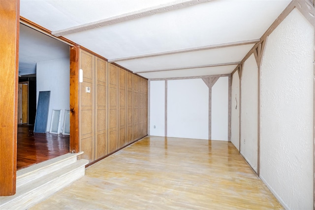 hall with beamed ceiling and light wood-type flooring