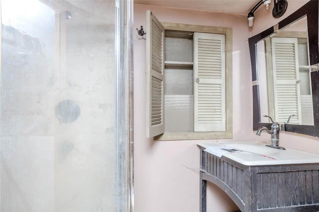 bathroom featuring vanity and a shower with door