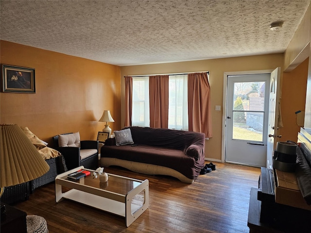 living room featuring a textured ceiling, baseboards, and dark wood-style flooring