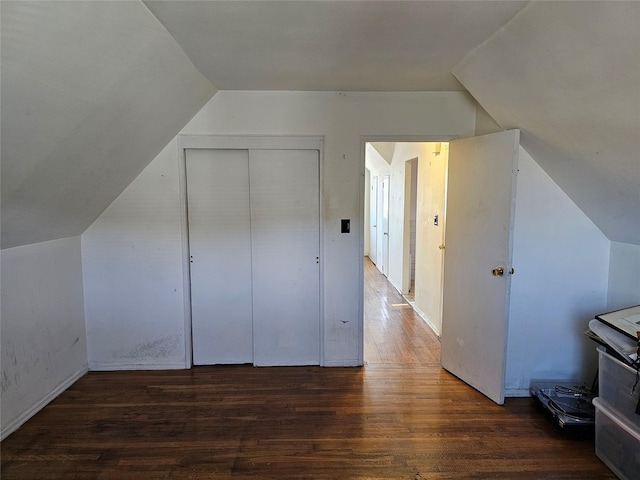 additional living space featuring dark wood-style flooring and vaulted ceiling