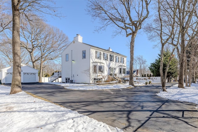 view of front of property with a chimney, an outdoor structure, and a detached garage