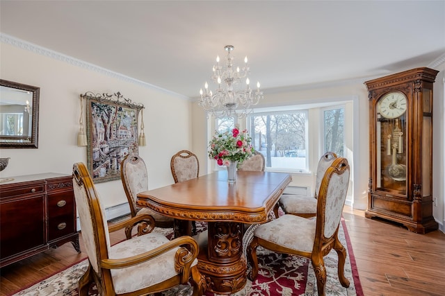 dining room with a chandelier, wood finished floors, and crown molding