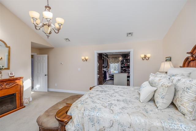 bedroom with light carpet, visible vents, an inviting chandelier, vaulted ceiling, and a walk in closet