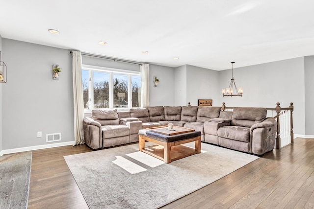 living room featuring a chandelier, recessed lighting, dark wood-type flooring, visible vents, and baseboards