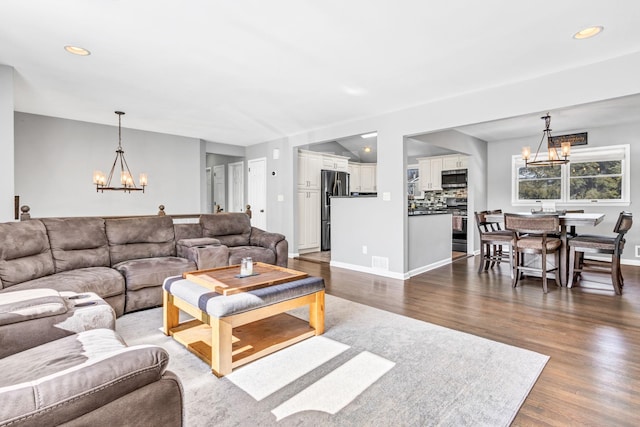 living room featuring visible vents, dark wood-style flooring, a notable chandelier, and recessed lighting