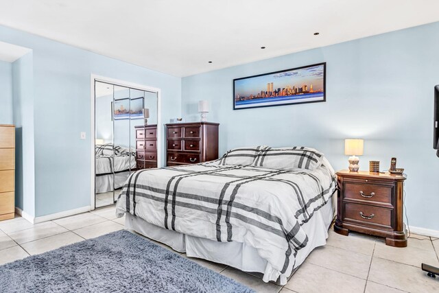 bedroom with light tile patterned flooring and baseboards