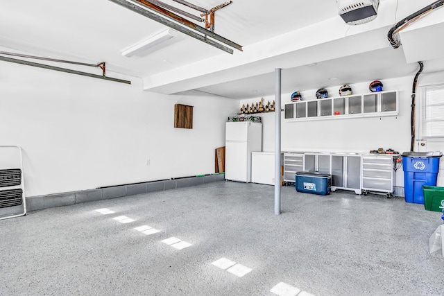 garage with freestanding refrigerator and a garage door opener