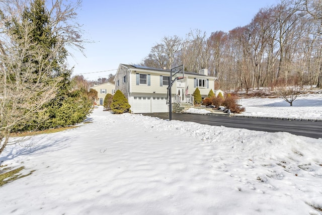 view of front of property with an attached garage and a chimney