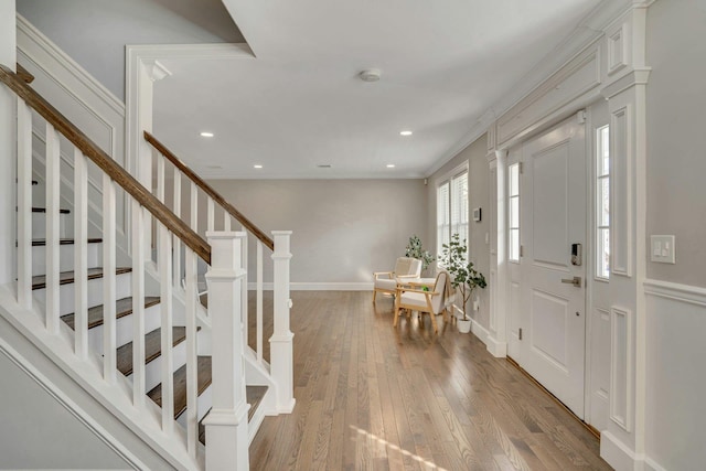 foyer featuring recessed lighting, baseboards, ornamental molding, stairway, and hardwood / wood-style floors