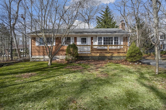 view of front of property featuring a chimney, a front lawn, and a wooden deck