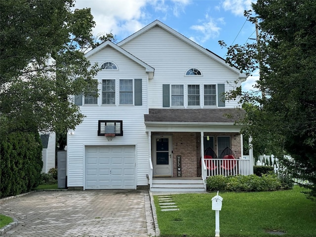 traditional-style home featuring decorative driveway, brick siding, a porch, a garage, and a front lawn