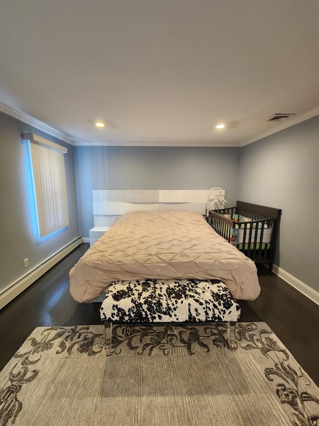bedroom with baseboards, visible vents, dark wood-style floors, baseboard heating, and crown molding