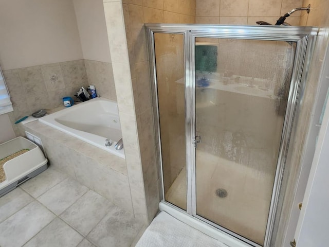 bathroom featuring a stall shower, a garden tub, and tile patterned floors