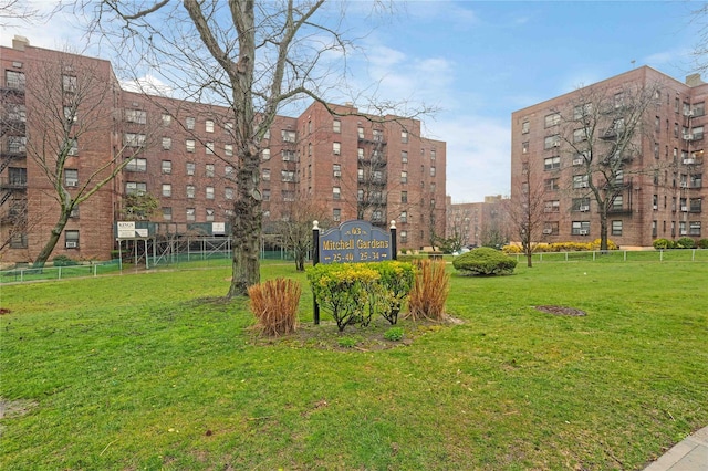 view of property's community featuring a yard and fence