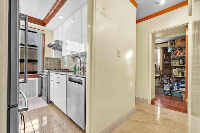 kitchen featuring under cabinet range hood, white cabinetry, stainless steel appliances, and crown molding