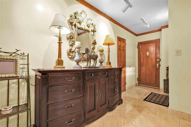 interior space with baseboards, marble finish floor, ornamental molding, and track lighting