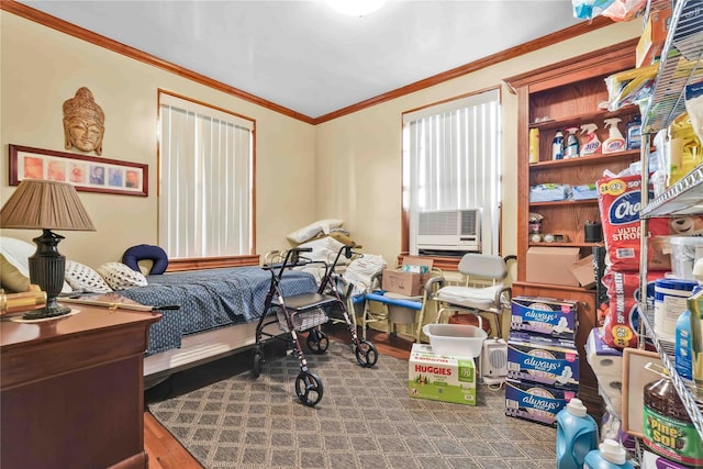 bedroom with ornamental molding and wood finished floors