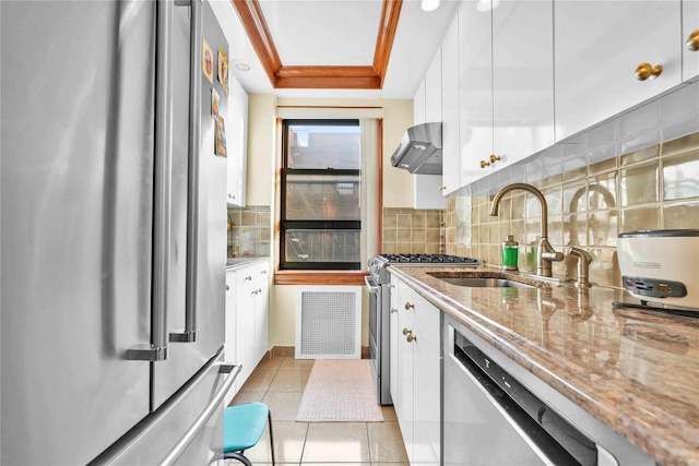 kitchen with visible vents, white cabinetry, appliances with stainless steel finishes, wall chimney range hood, and light stone countertops