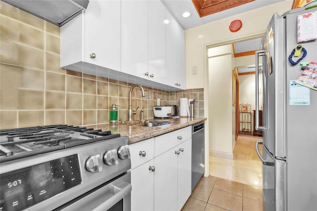 kitchen featuring extractor fan, stainless steel appliances, a sink, white cabinetry, and light stone countertops