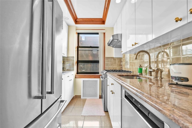 kitchen with light stone counters, visible vents, appliances with stainless steel finishes, white cabinets, and wall chimney exhaust hood