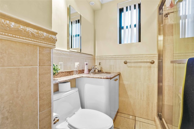 bathroom featuring a wainscoted wall, tile walls, a stall shower, vanity, and tile patterned flooring