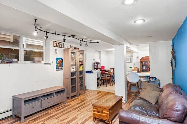 living room with baseboard heating, track lighting, and light wood-type flooring