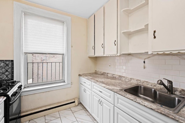 kitchen with sink, light stone counters, white cabinetry, black range with gas stovetop, and baseboard heating