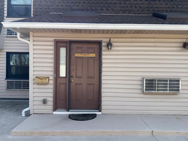 property entrance with a shingled roof