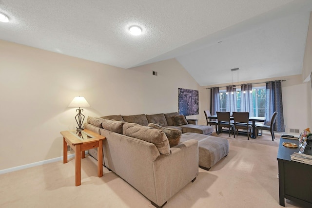 living area featuring light carpet, vaulted ceiling, visible vents, and a textured ceiling