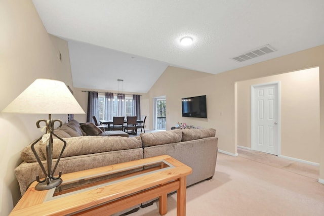 living room with visible vents, vaulted ceiling, light carpet, and baseboards