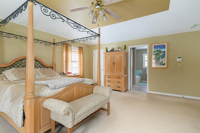 bedroom featuring connected bathroom, baseboards, vaulted ceiling, and light colored carpet