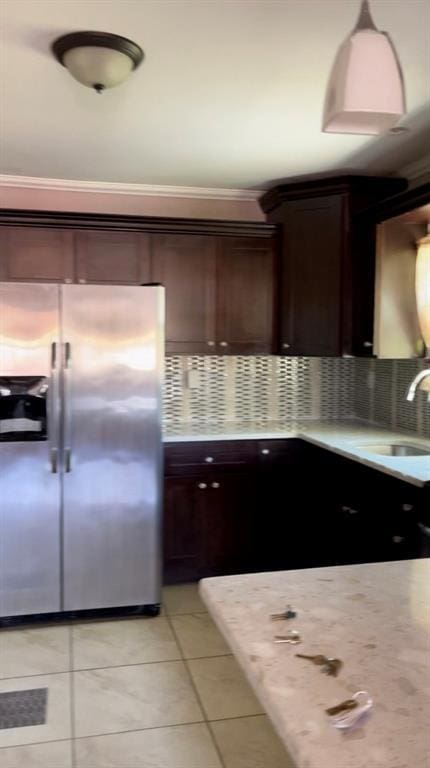 kitchen with dark brown cabinetry, light countertops, a sink, and stainless steel fridge with ice dispenser