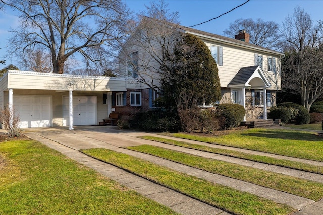 view of front of property featuring brick siding, a chimney, concrete driveway, an attached garage, and a front yard