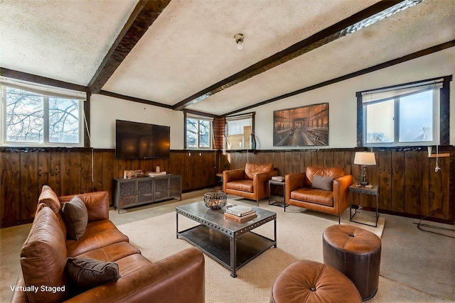 carpeted living room with lofted ceiling with beams, wood walls, a textured ceiling, and wainscoting